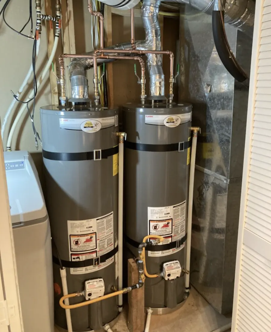 Two gas tank water heaters installed side by side in a utility closet &mdash; Foothills Water Heaters